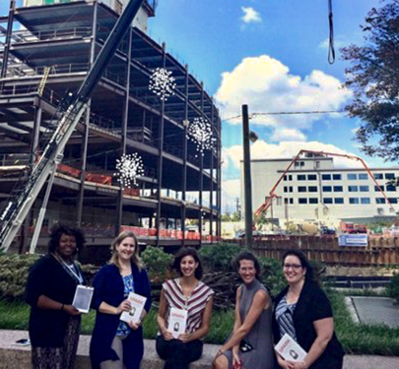 Dominion construction site and readers holding the book